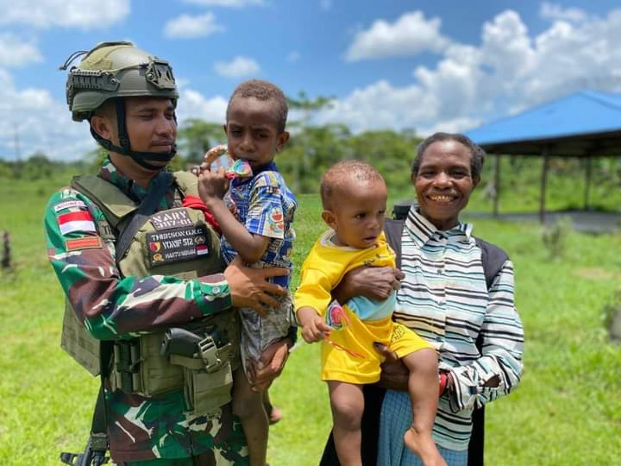 Anggota Satgas Yonif 512/QY menggendong anak Papua