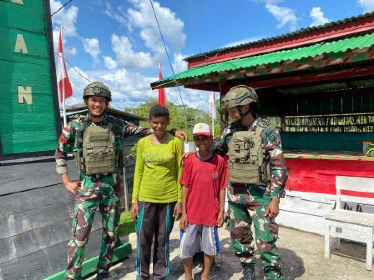 Dua anak membawa sayuran segar hasil petik dari kebun untuk diberikan kepada Kakak Tentara