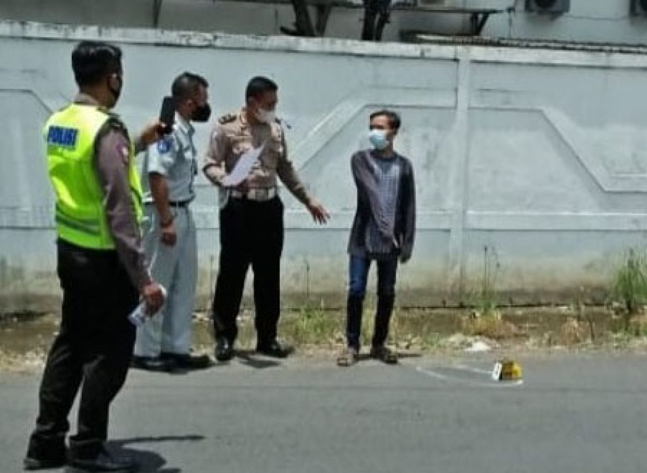 Rino Putra Firmansyah (kanan) bersama anggota Polres Gresik menunjuk lokasi ditemukannya jasad Saputra