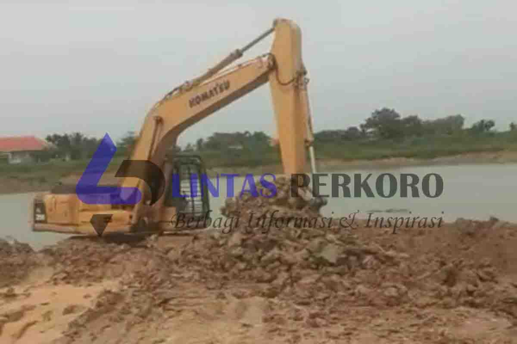 Excavator mengeruk tanah di lahan waduk di Desa Punduttrate