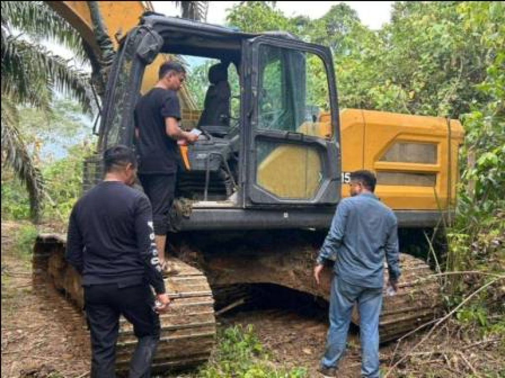 Petugas Polda Sumatera Barat memasang garis polisi ke excavator