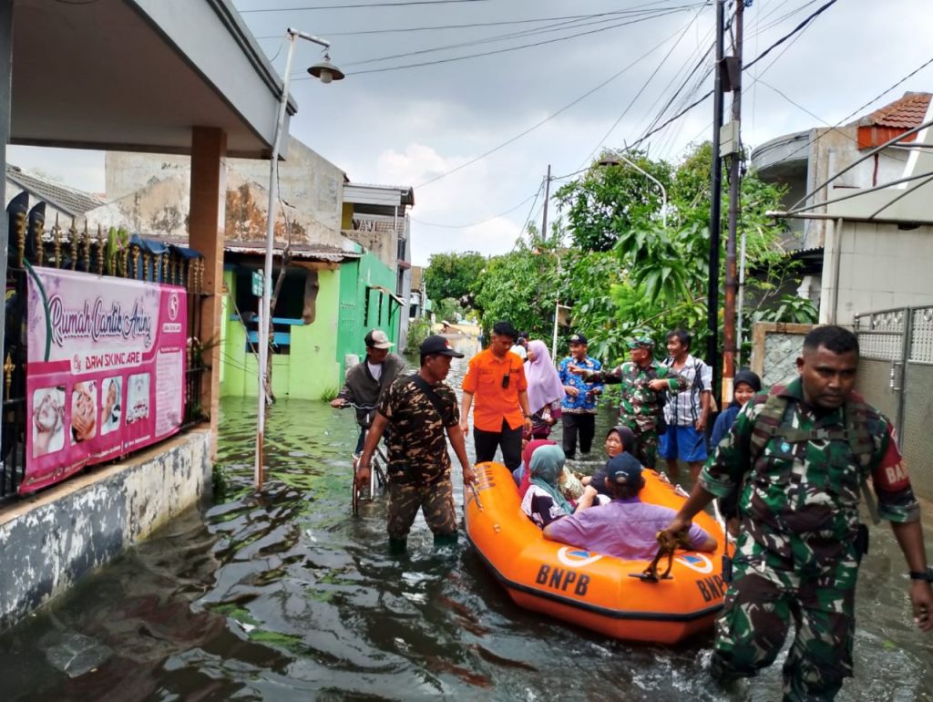 Kapten Inf Ghofur Urokhim bersama anggota Koramil 0816/14 Taman bahu-membahu dalam operasi evakuasi warga
